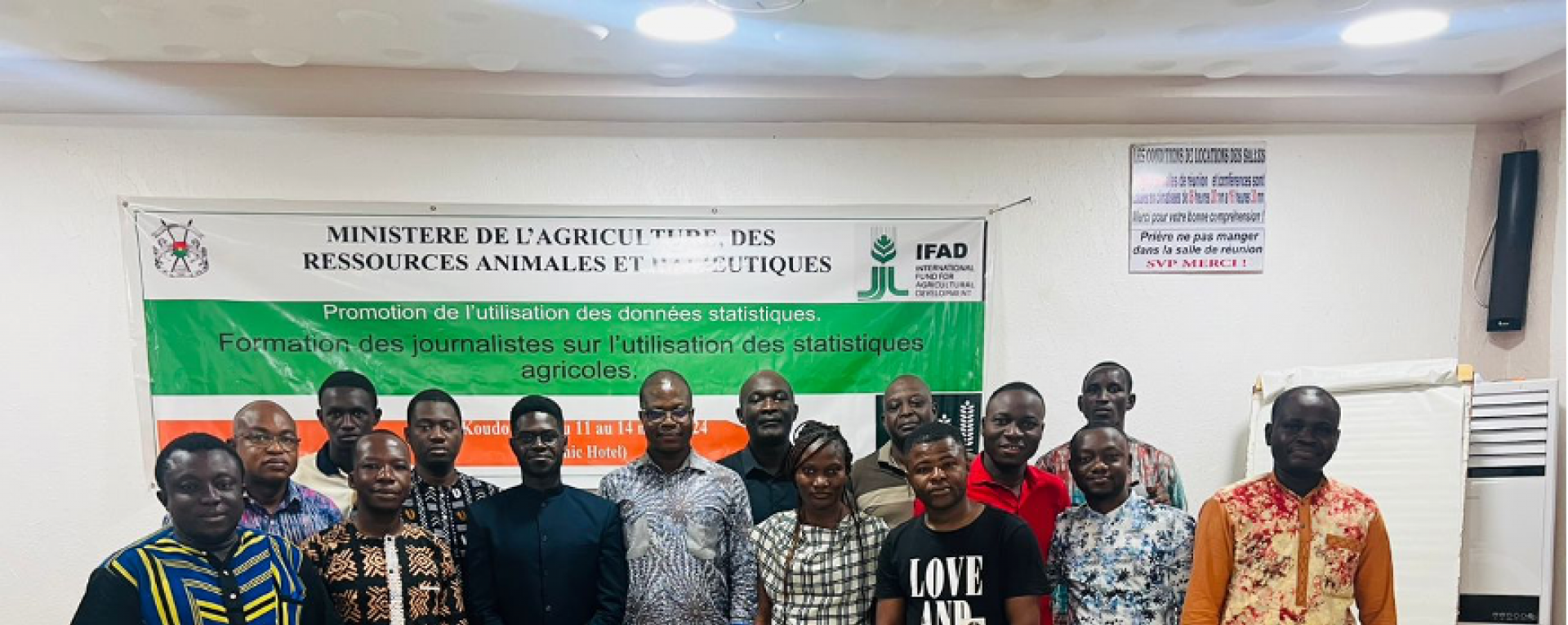 Workshop attendees posing in front of banner